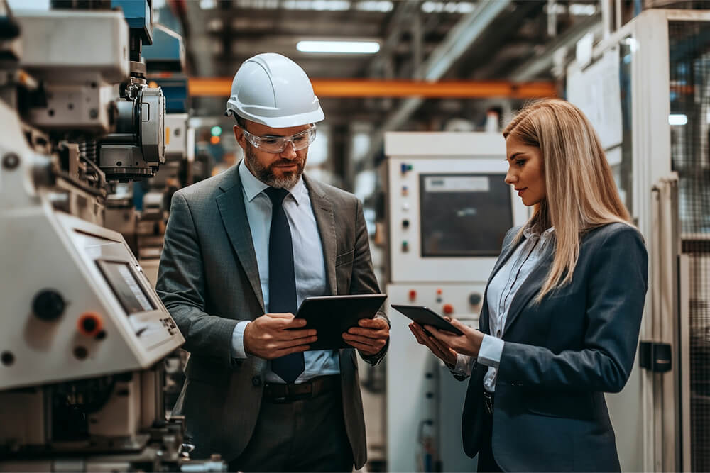 man-woman-looking-tablet-factory